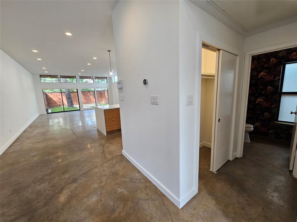 Polished concrete flooring, recessed lighting, expansive glass windows, and a sliding door panel system