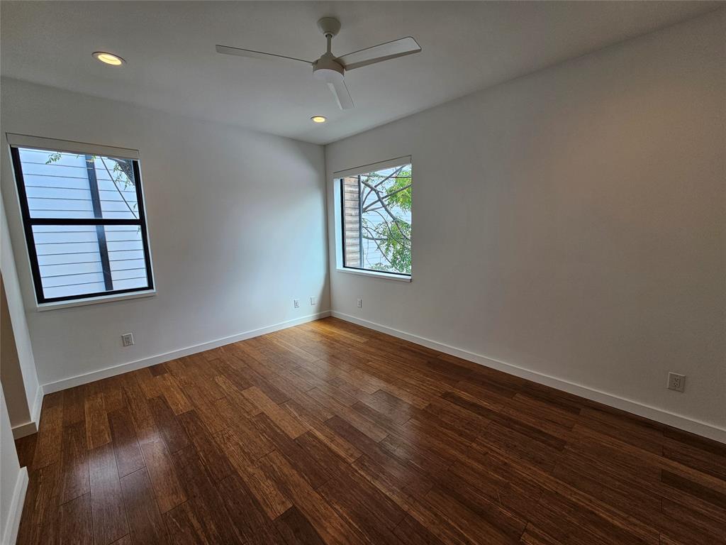 Room featuring wood-finish flooring, recessed lighting, a modern ceiling fan, and dual windows