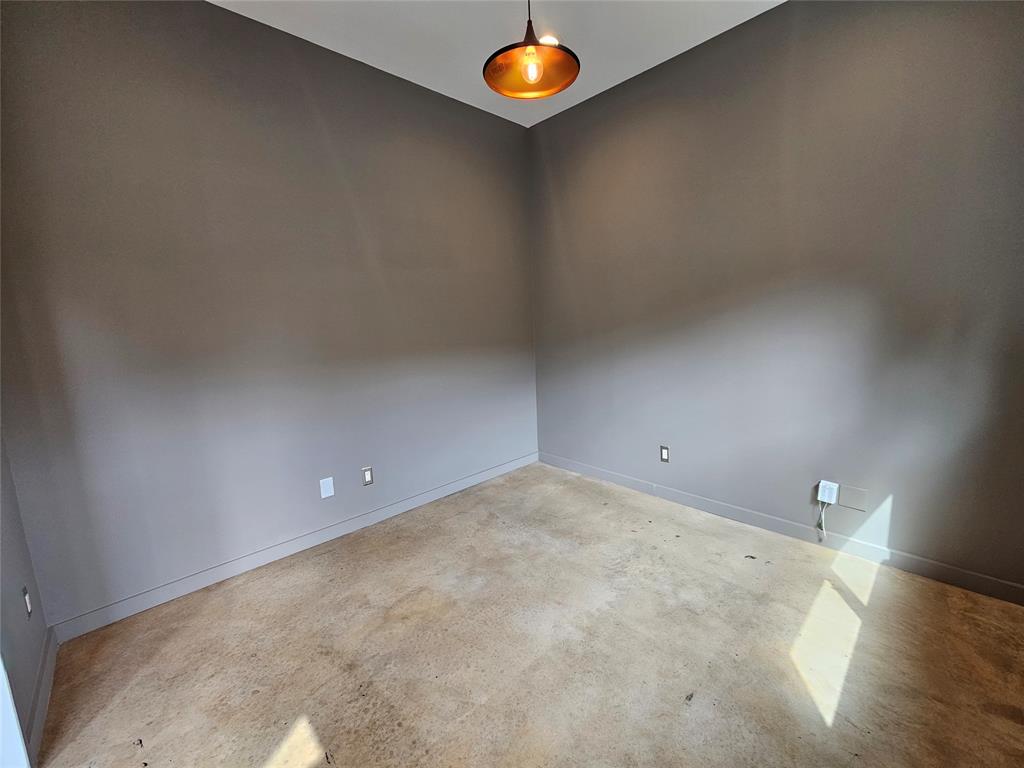 Neutral-toned walls, polished concrete flooring, and a contemporary metal pendant light fixture