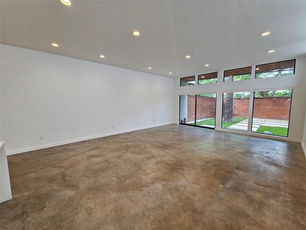 Polished concrete flooring, recessed lighting, and expansive floor-to-ceiling windows