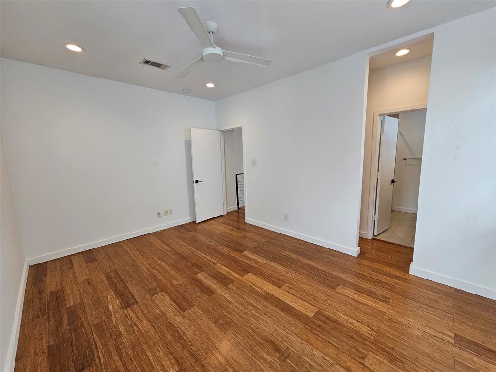 Room featuring wood-finish flooring, recessed lighting, a modern ceiling fan, and white interior doors