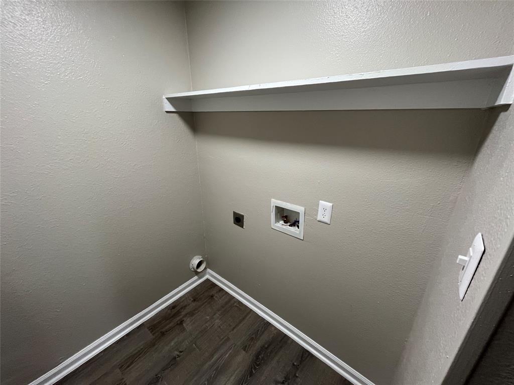 Utility area featuring wood-finish flooring and a built-in floating shelf