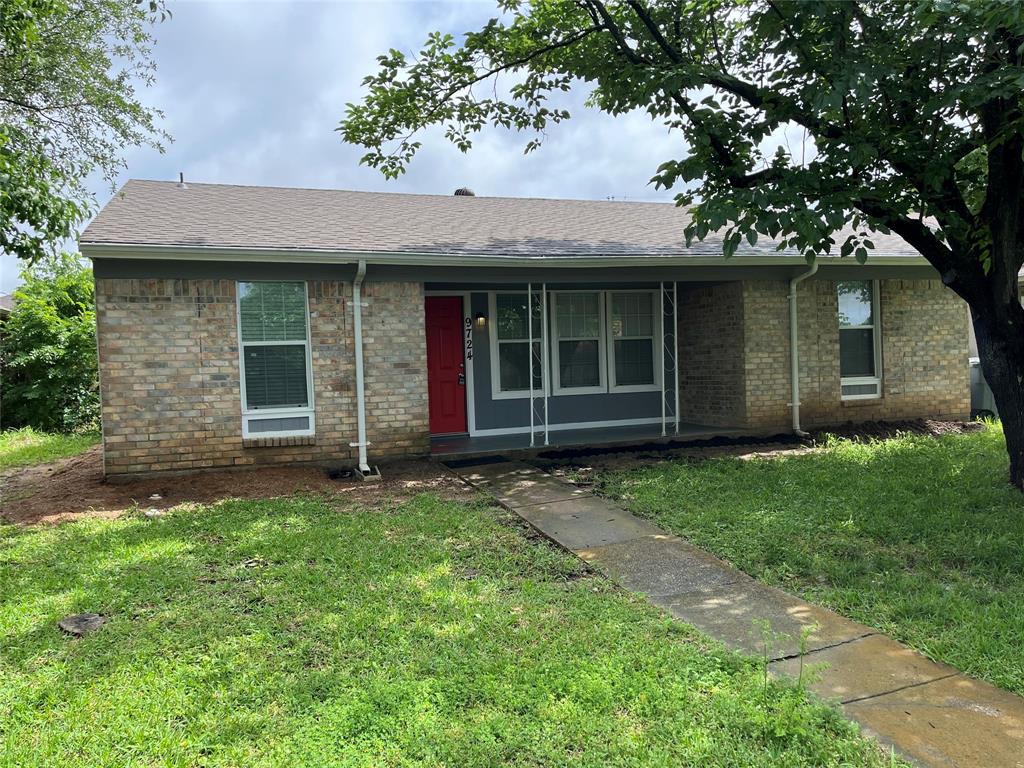Single-story brick exterior featuring a recessed front porch, metal support columns, a vibrant red entry door, and a concrete walkway