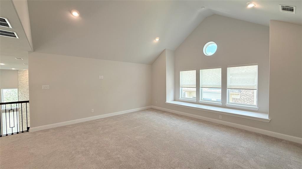 Vaulted ceiling featuring recessed lighting, a circular accent window, and a built-in window seat