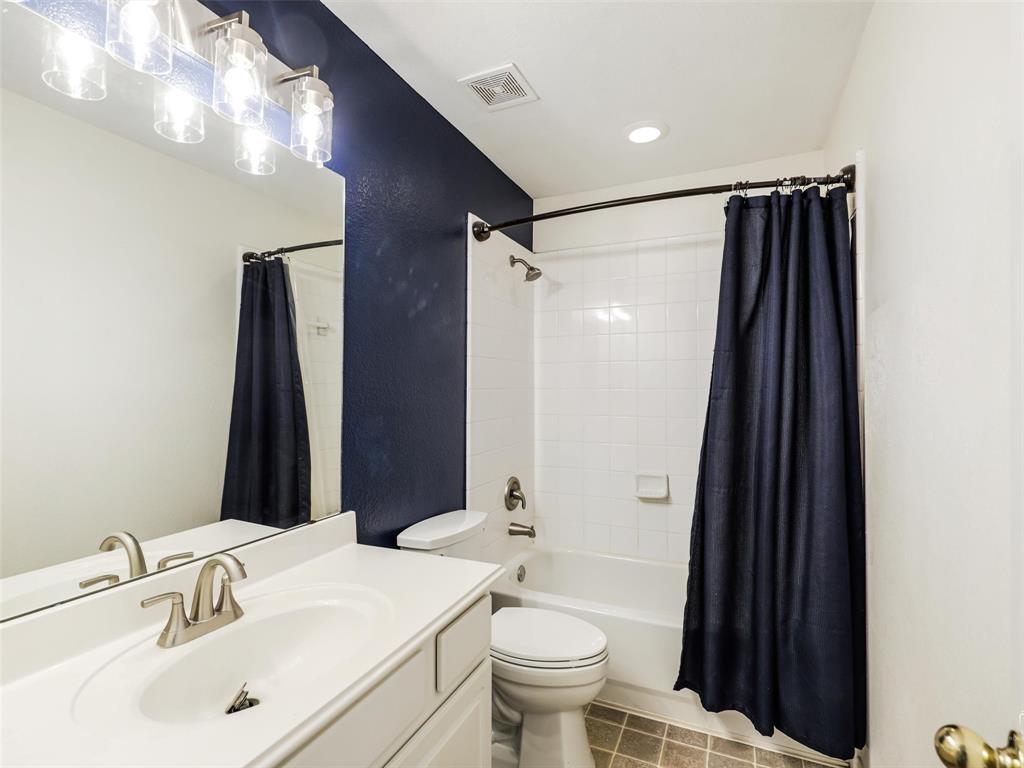 Bathroom featuring a white vanity with an integrated sink, polished chrome faucet, full-width mirror, multi-light fixture, and a tiled tub-shower combination