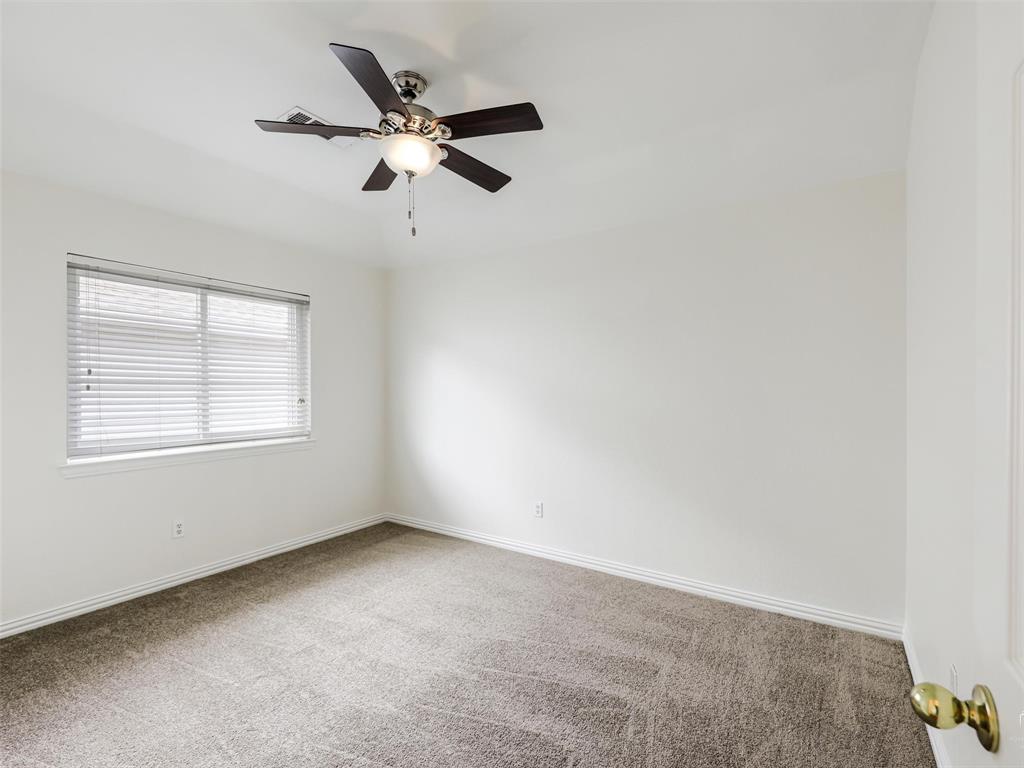 Neutral-toned wall-to-wall carpeting, window with integrated blinds, and ceiling fan with central light fixture