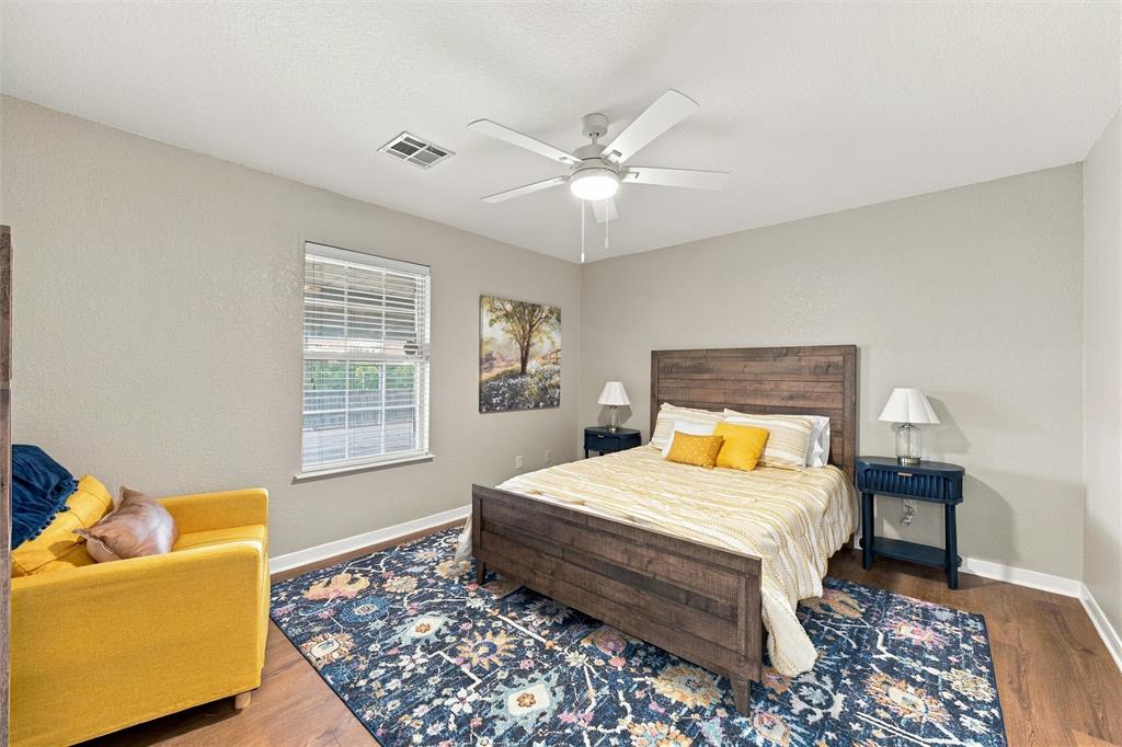 Room featuring wood-finish flooring, a neutral paint palette, and a white ceiling fan with integrated lighting