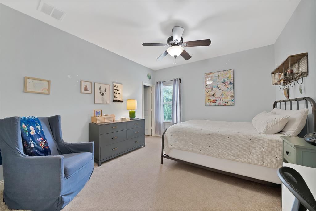 Neutral-toned carpeted flooring, multi-speed ceiling fan with integrated lighting, and window with natural light exposure