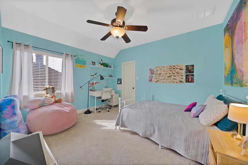 Vaulted ceilings, neutral carpeting, and a ceiling-mounted light fixture with integrated fan