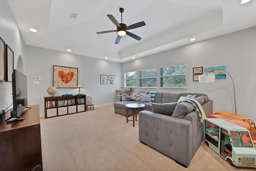 Tray ceiling featuring recessed lighting and a central ceiling fan, expansive triple-pane window configuration, and neutral wall tones