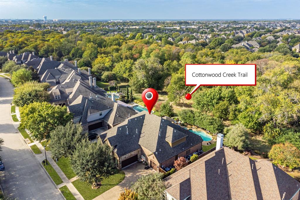 Aerial perspective featuring a multi-gabled roofline, private backyard swimming pool, and immediate proximity to wooded greenspace