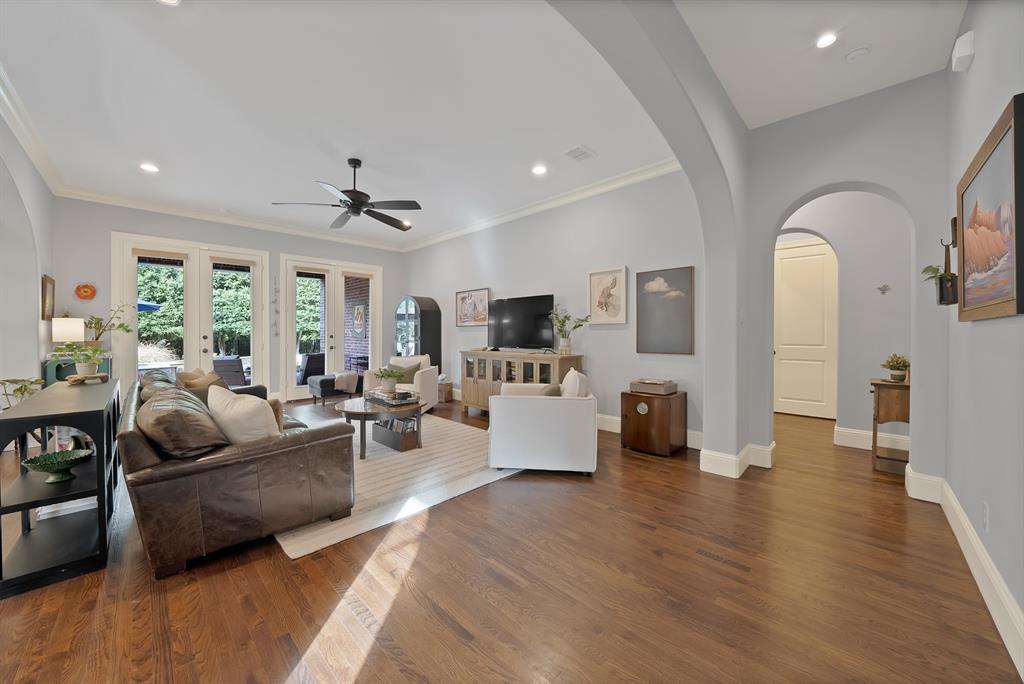 Spacious interior featuring wood-finish flooring, recessed lighting, crown molding, and architectural arched doorways