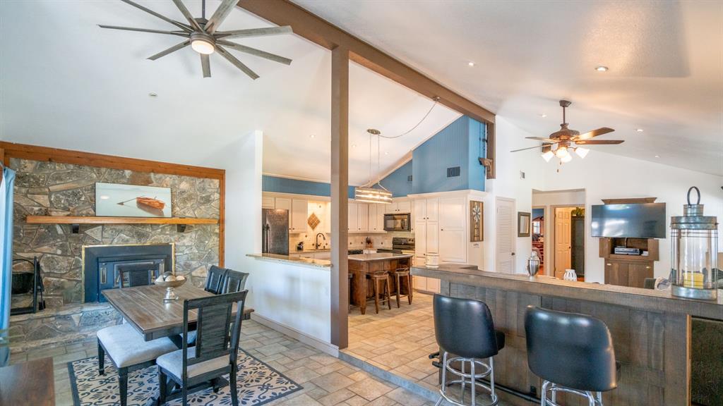 Open layout for kitchen, dining, living areas and added bar. Wood burning fireplace and mantel for winter entertaining.