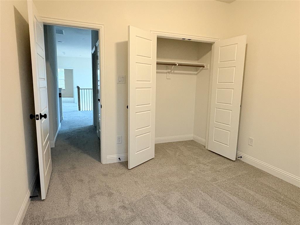 Neutral interior featuring wall-to-wall carpeting, five-panel interior doors, and a built-in closet with overhead hanging rod