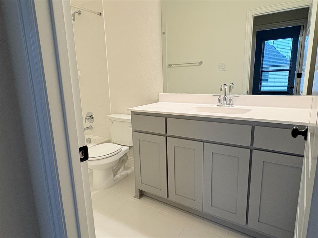 Bathroom featuring a grey vanity with a white countertop, undermount sink, chrome faucet, full-width mirror, and a tub-shower combination
