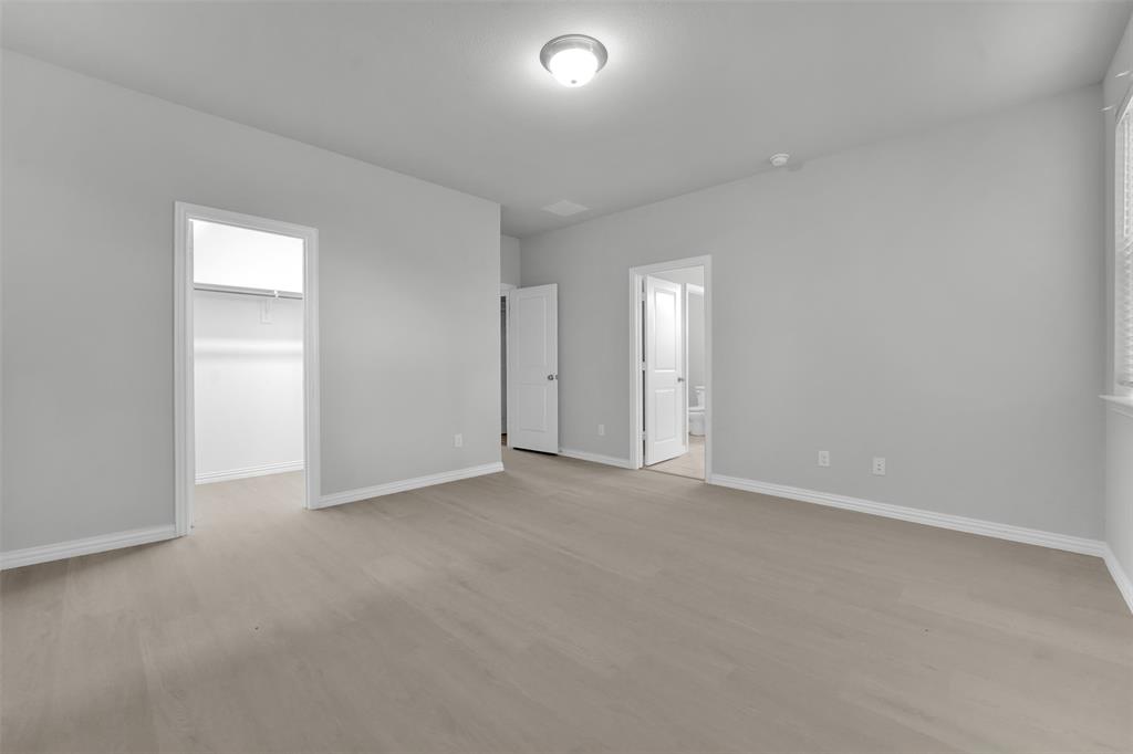 Spacious room with wood-finish flooring and neutral wall tones
