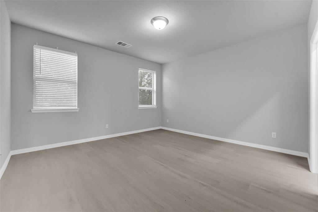 Wood-finish flooring, multiple windows with blinds, recessed lighting, and light gray wall finishes