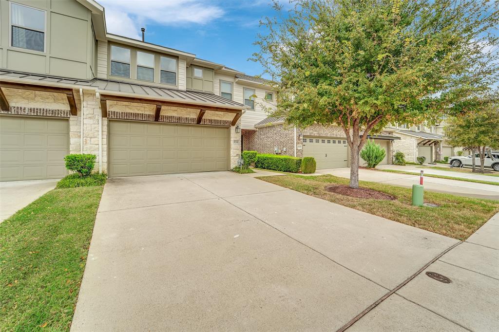 Two-story exterior with stone and siding accents, prominent garage with a covered entrance, and a concrete driveway