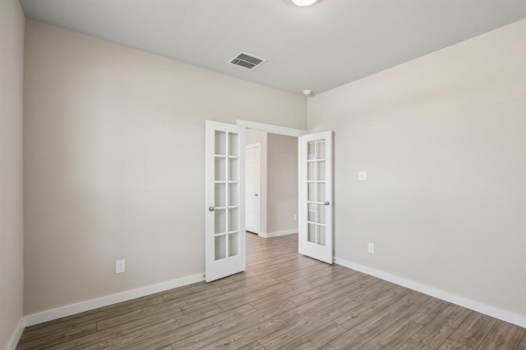 Room featuring wood-finish flooring and double French doors with glass panes