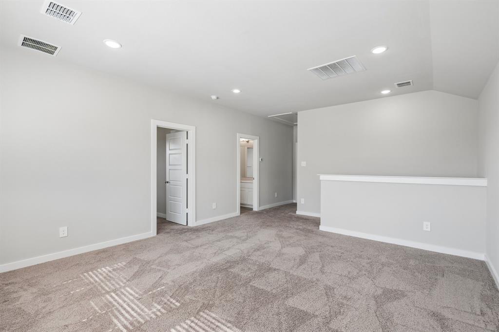 Neutral-toned carpeted flooring, vaulted ceiling, recessed lighting, and four-panel interior doors