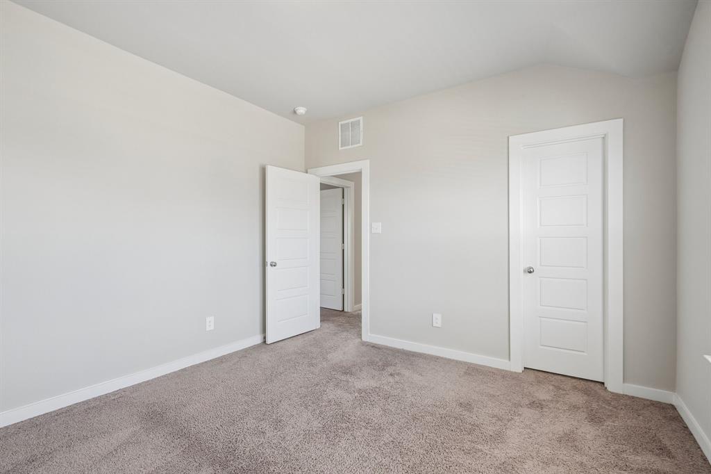 Interior room featuring neutral-toned carpeting, high ceilings, and white four-panel interior doors