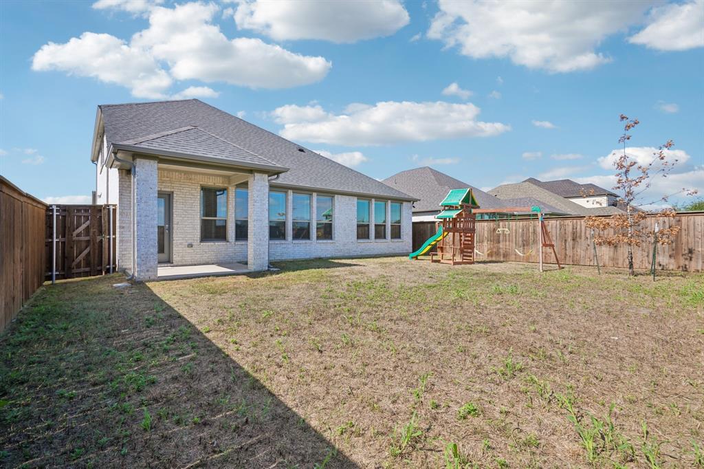 Brick exterior with a covered rear patio and wood privacy fencing
