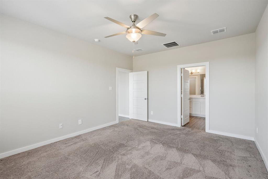 Neutral-toned interior featuring wall-to-wall carpeting, a ceiling fan with integrated light fixture, and white-paneled interior doors