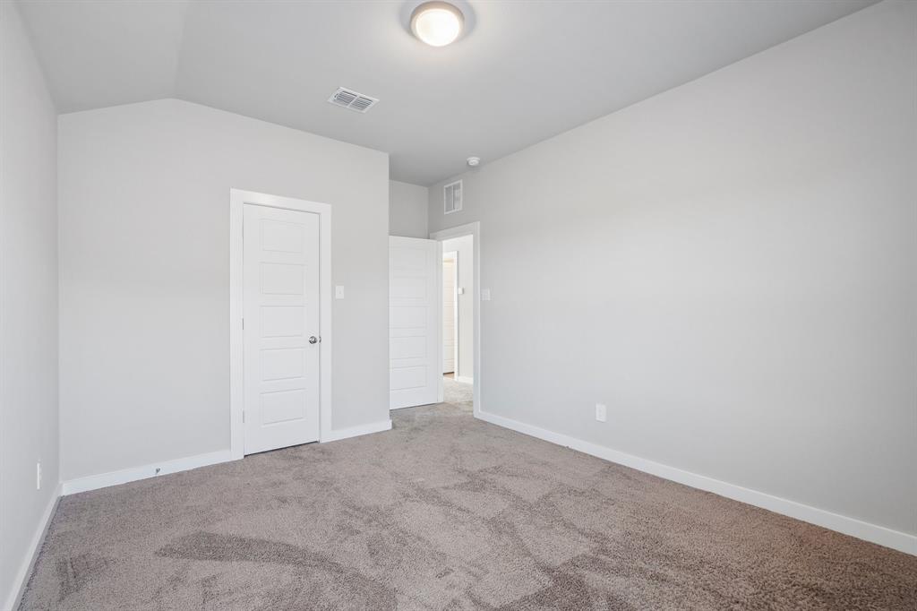Interior room featuring neutral-toned carpeting, high ceilings, flush-mount lighting, and four-panel interior doors