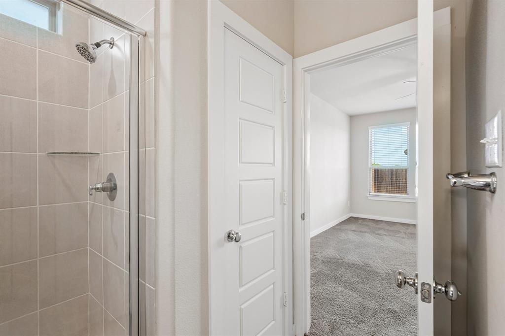 Tiled walk-in shower with a glass enclosure, five-panel door, and wall-to-wall carpeting