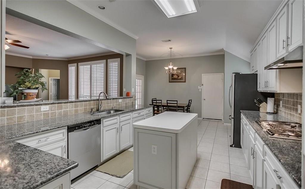 Kitchen featuring white cabinetry, stone countertops, a center island with a solid surface top, tiled backsplash, and recessed ceiling lighting