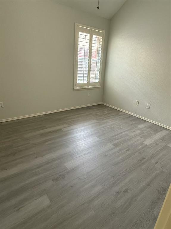 Vaulted ceiling, wood-finish flooring, and plantation shutters