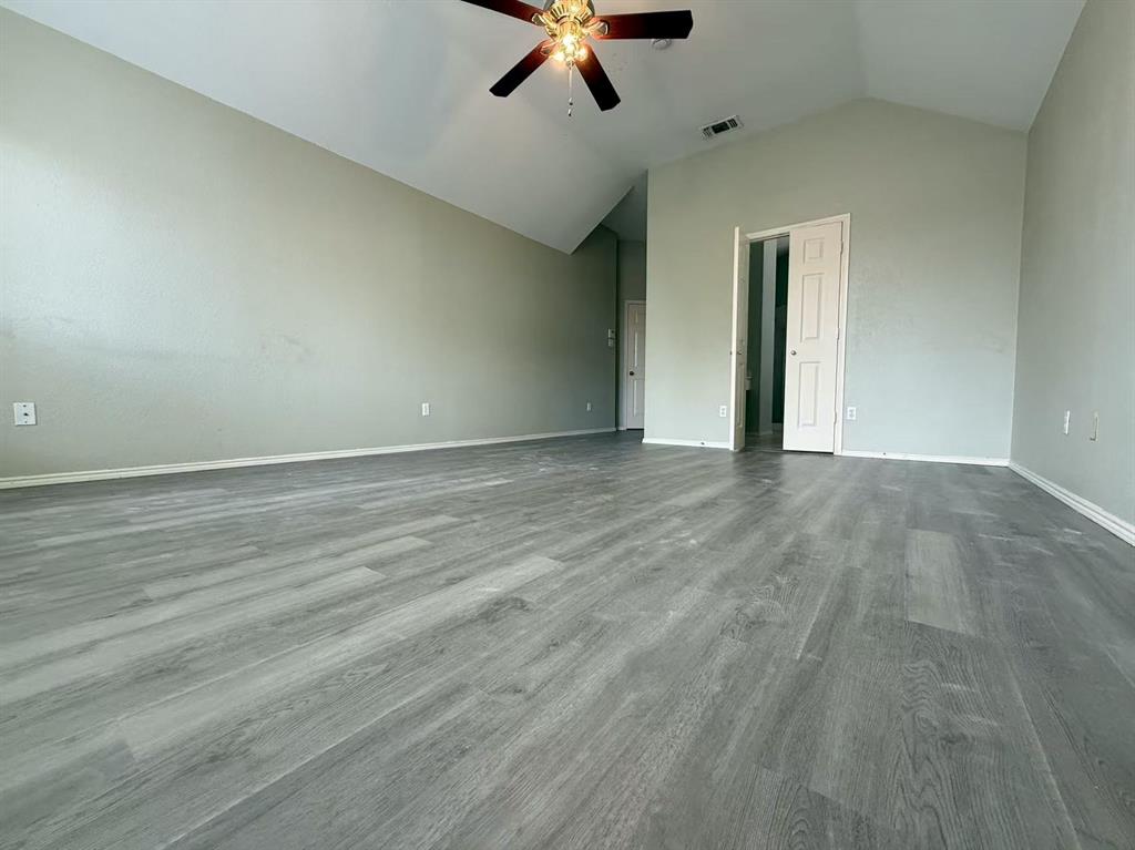 Vaulted ceilings, wood-finish flooring, and a ceiling fan with integrated lighting