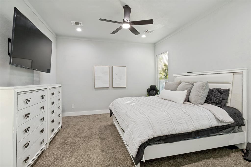 Neutral-toned interior featuring plush carpeting, crown molding, recessed lighting, and a modern ceiling fan