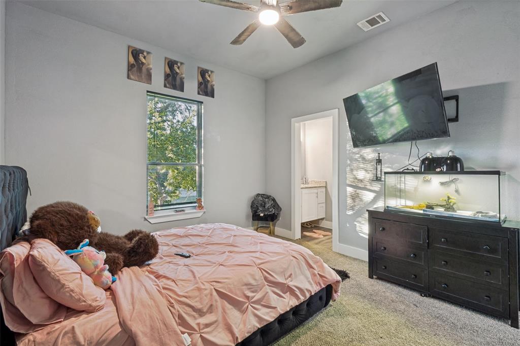 Neutral-toned interior featuring carpeted flooring, a ceiling fan with light fixture, and a window with blinds