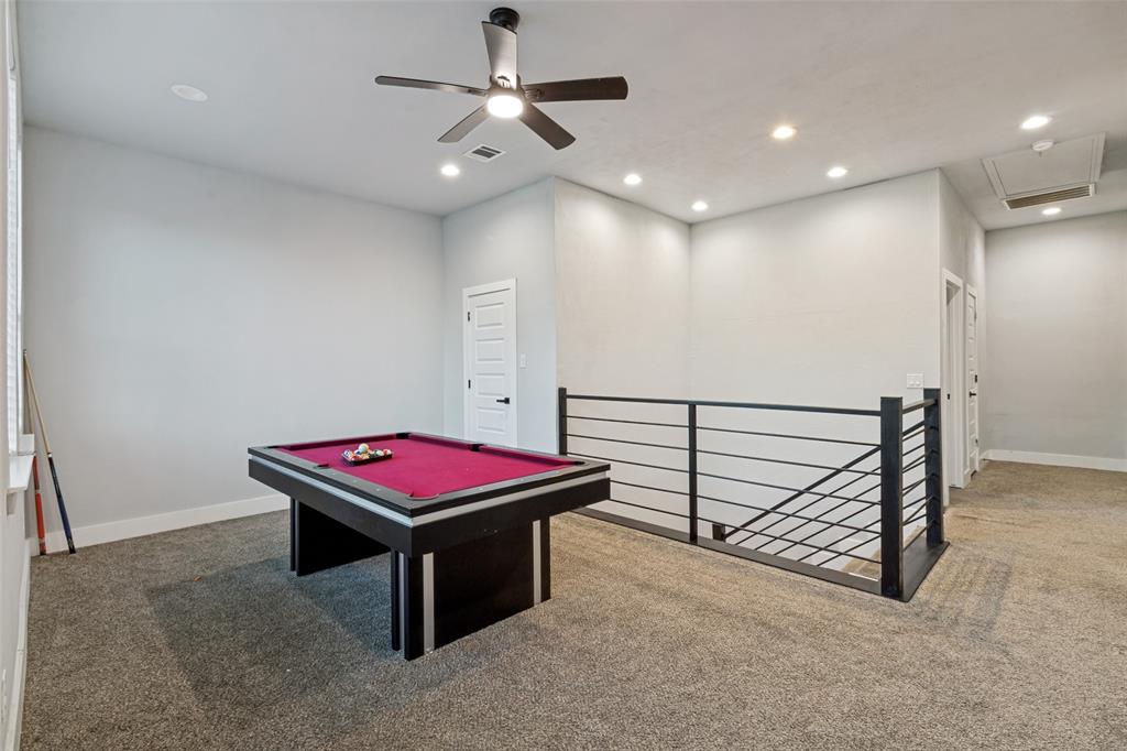Interior space featuring neutral-toned carpeting, recessed lighting, a modern ceiling fan, and a metal horizontal-bar stair railing