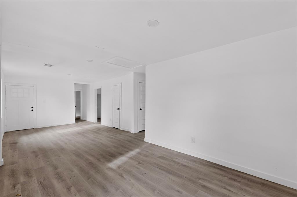 Neutral interior space featuring wood-finish flooring, recessed lighting, and multi-panel interior doors
