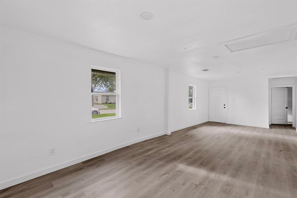 Interior space featuring wood-finish flooring, recessed lighting, white walls, and multiple single-hung windows