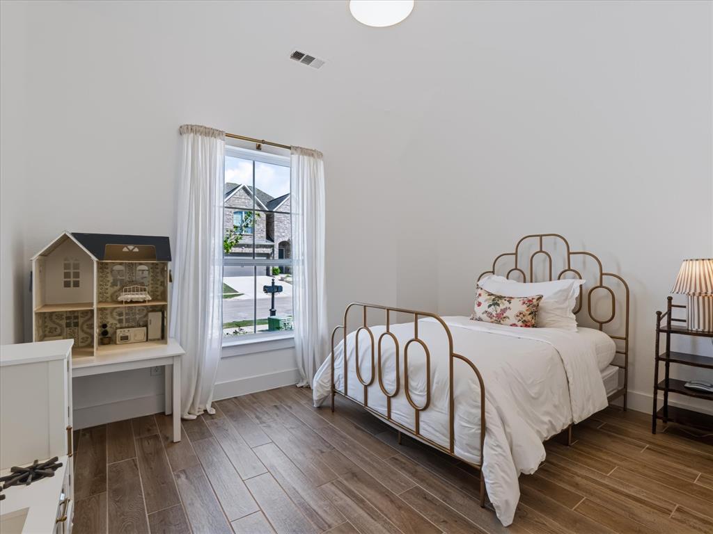 Vaulted ceilings, wood-finish flooring, and natural light from a window with a multi-pane grid