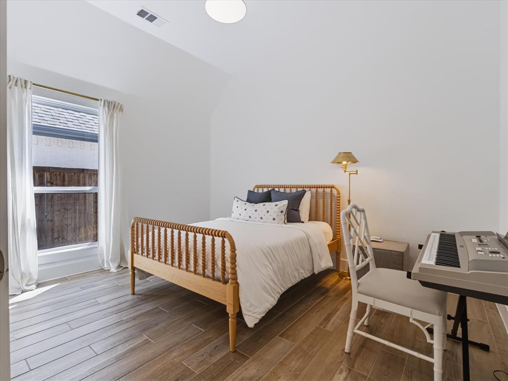 High ceilings, wood-finish flooring, and natural lighting provided by a large window
