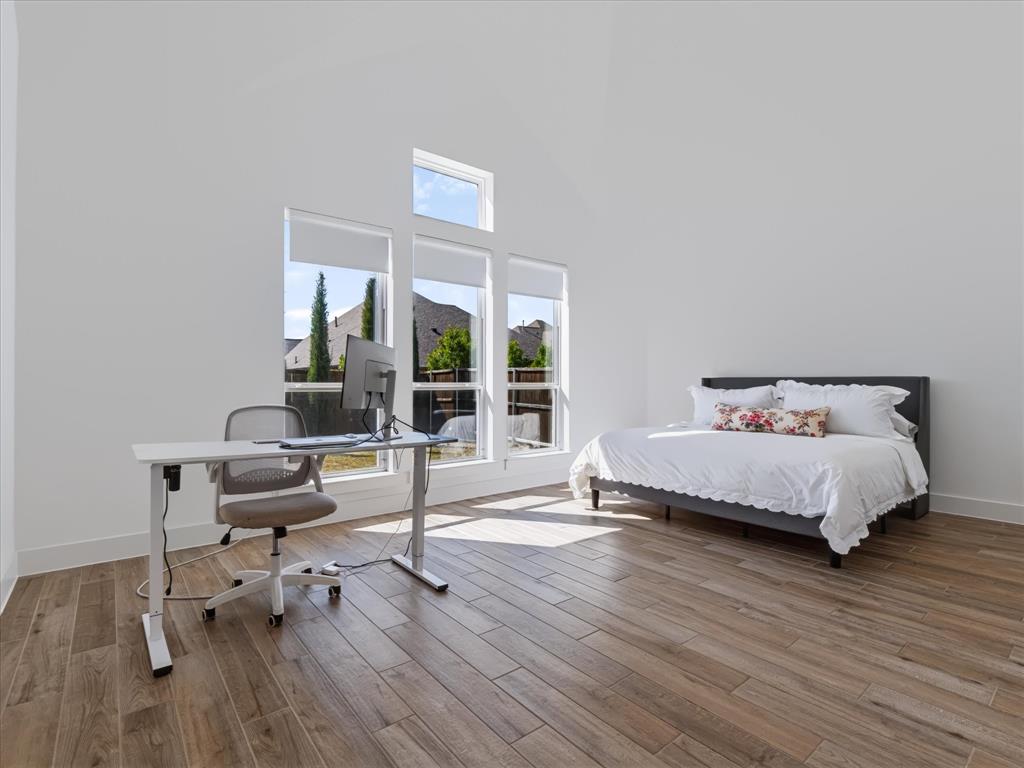 High-vaulted ceilings featuring wood-finish flooring and expansive vertical window groupings