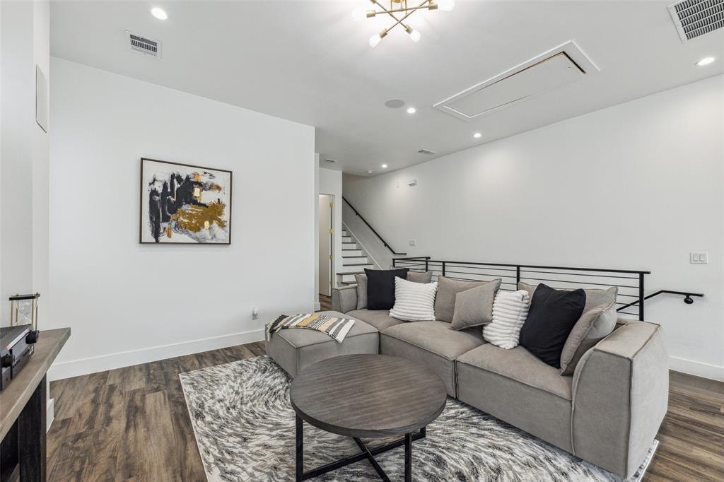 Living room with dark hardwood / wood-style flooring and an inviting chandelier