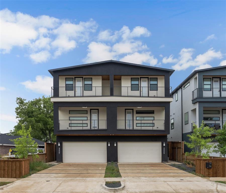 View of front facade featuring a balcony and a garage