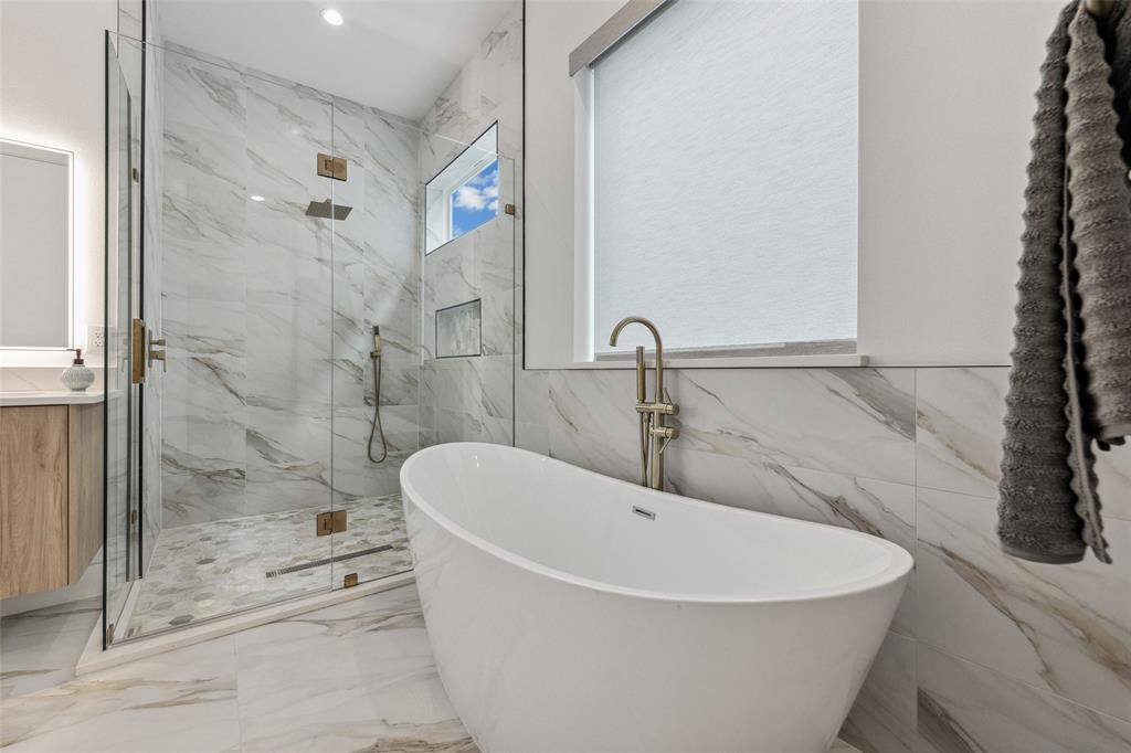 Bathroom with plus walk in shower, tile walls, tile patterned flooring, and vanity