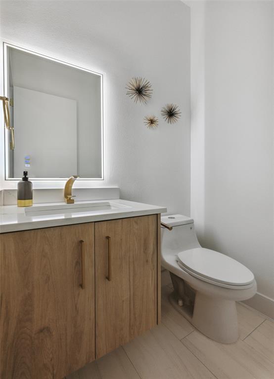 Bathroom featuring tile patterned flooring, toilet, and vanity