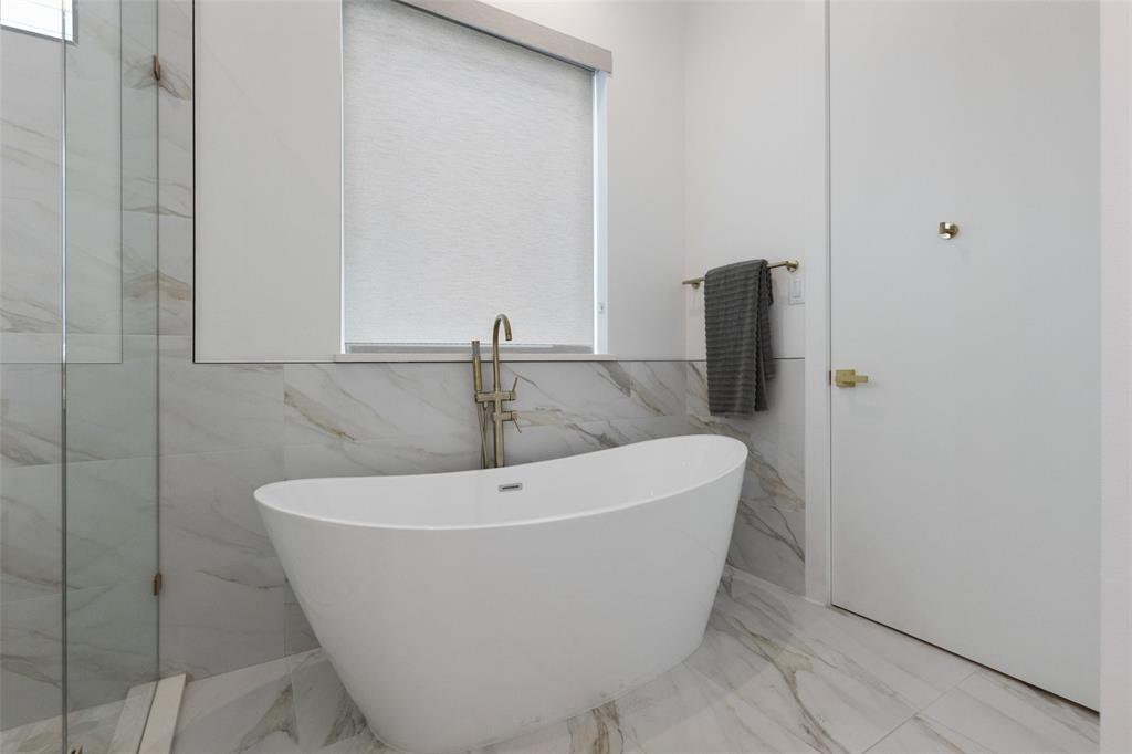 Bathroom with plus walk in shower, tile patterned flooring, and tile walls