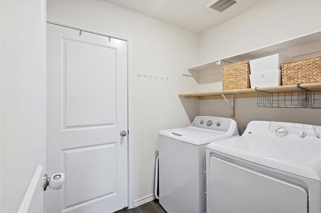 Laundry area featuring a multi-panel door, built-in shelving, and wall-mounted garment hooks