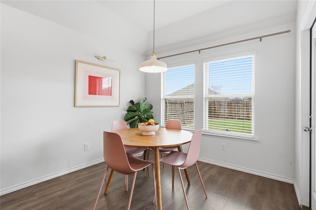 Wood-finish flooring, dual windows with horizontal blinds, neutral wall palette, and dome pendant lighting