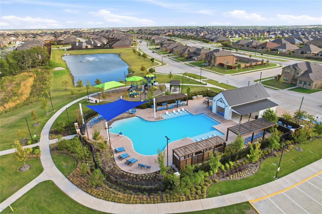 Community amenity complex featuring an expansive swimming pool, multiple shaded pergola structures, a dedicated playground, and a pond with a central fountain