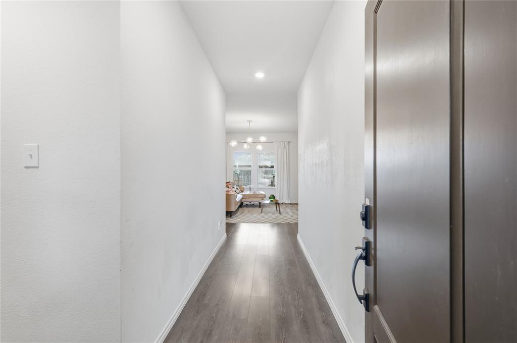Entryway featuring wood-finish flooring, neutral walls, recessed lighting, and a dark-finish entry door with a lever handle and electronic deadbolt