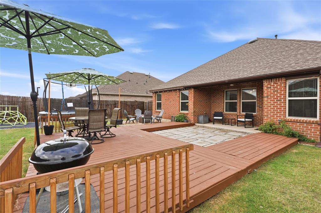 Multi-level wood deck, stone-paver patio area, and brick exterior finish